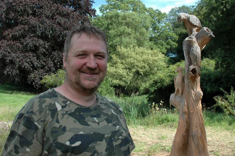 Sculpture monumentale sur bois à la tronçonneuse dans une forêt française.